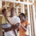 Four Good Reasons to Build a Custom Home A family stands in their new custom home being built.
