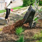 Grow Your Home’s Value with These DIY Landscaping Tips Wheelbarrow full of Mulch